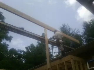 Carpenter setting a ridge beam over a new addition frame — Ice Dam Removal by Roofing Brothers in Muscotah