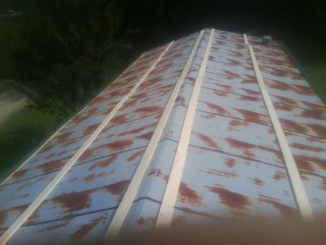 Rusted metal roof panels with new wood purlins before replacement — Storm Damage Roof Repair in Muscotah by Roofing Brothers